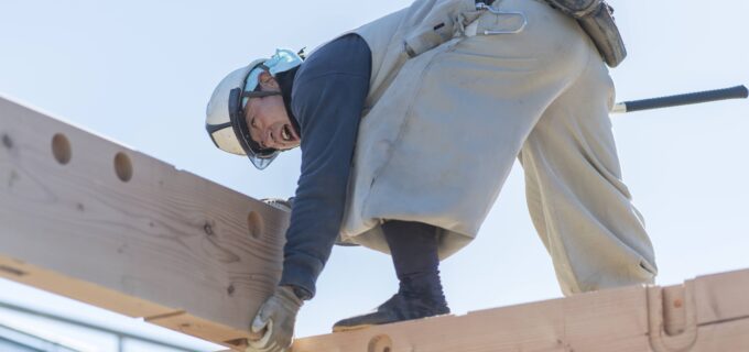 手作業で家を組み立てる大工